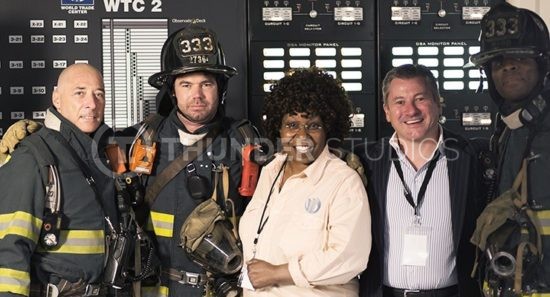 Rodric David and Whoopi Goldberg with casgt members portraying firefighters during filming Nine Eleven at Thunder Studios